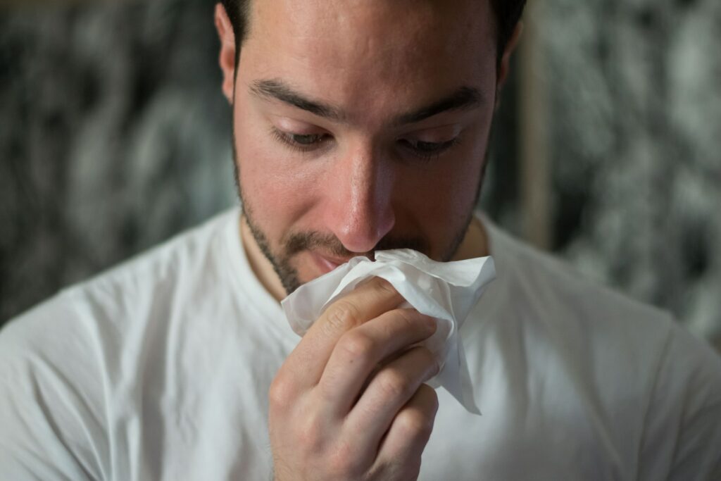 Man holding a tissues to their nose